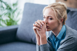 Woman holding hands to face looking off in a daze