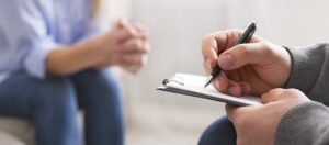 Counseling-Palatine-IL-man-writing-while-woman-sits-in-the-background